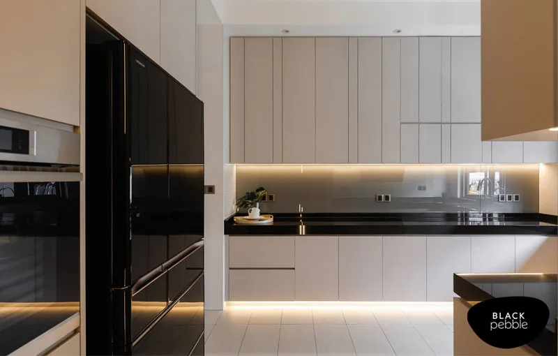 Sleek modular kitchen by interior designer in Mangalore with black countertop and under-cabinet lighting
